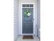 Inviting front door with a decorative wreath and a 'Welcome' sign, set in a light grey exterior at 202 Tall Grass Ct, Summerville, SC 29483