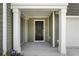 Inviting front porch with white columns and security system at 204 Cozy Brook Ct, Summerville, SC 29486