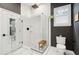 Modern bath features a glass shower with a teak bench, striking white tile and contrasting gray wall paint at 2166 Welch Ave, Charleston, SC 29412