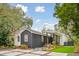 Striking home showcasing a dark-stained wood siding, with a paved driveway and mature landscaping at 2166 Welch Ave, Charleston, SC 29412