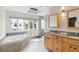 Bright bathroom with tub, double vanity, walk-in shower with glass block, and skylight at 2276 Seascape Ct, Seabrook Island, SC 29455