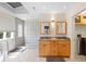 Bright bathroom featuring double vanities, a walk-in shower with glass block, and a skylight at 2276 Seascape Ct, Seabrook Island, SC 29455