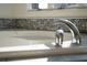 Close-up of a luxurious bathtub with a chrome faucet and decorative tile surround at 2276 Seascape Ct, Seabrook Island, SC 29455