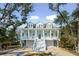Charming two-story home featuring a double front porch, white railings, and a ground-level garage at 2514 Bullock Guard Dr, Johns Island, SC 29455