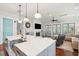 Open kitchen featuring a center island with a sink, quartz countertops, and view to the living room at 2514 Bullock Guard Dr, Johns Island, SC 29455