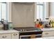 Close-up of kitchen with stainless steel range, light gray backsplash and white cabinetry at 2514 Bullock Guard Dr, Johns Island, SC 29455