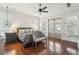 Bright main bedroom featuring hardwood floors, ensuite bathroom, and a stylish hanging chair at 2514 Bullock Guard Dr, Johns Island, SC 29455