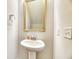 Small powder room includes a pedestal sink, gold framed mirror, and essential amenities at 2905 Cavalcade Cir, Johns Island, SC 29455