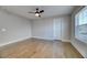 An empty bedroom with hardwood floors, ceiling fan, a window, and white door at 2905 Cavalcade Cir, Johns Island, SC 29455