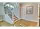 Staircase features hardwood stairs, white trim, black metal balusters, and beach themed decor at 2905 Cavalcade Cir, Johns Island, SC 29455