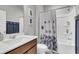 Modern bathroom featuring a tub with shower, a wood vanity with white sink, and decorative wall art at 302 Autumn Azalea Way, Summerville, SC 29486