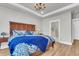 Bright bedroom featuring a tray ceiling, chandelier, wood flooring, and ensuite bathroom at 302 Autumn Azalea Way, Summerville, SC 29486