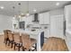 Bright kitchen features a large island with counter seating, white cabinets, and modern stainless steel appliances at 302 Autumn Azalea Way, Summerville, SC 29486