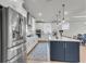 Modern kitchen with stainless steel appliances, a large island, and white cabinets, perfect for cooking and entertaining at 302 Autumn Azalea Way, Summerville, SC 29486