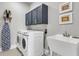 Well-equipped laundry room with new front load washer and dryer and sink at 302 Autumn Azalea Way, Summerville, SC 29486