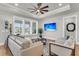 Cozy living room with a ceiling fan, large windows, and comfortable seating, perfect for relaxation at 302 Autumn Azalea Way, Summerville, SC 29486