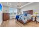 Comfortable bedroom with a large window, dresser, and bed with stylish blue patterned bedding at 302 Autumn Azalea Way, Summerville, SC 29486