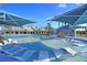 Beautiful zero entry pool with submerged lounge chairs and blue sunshades at Latitude Margaritaville Watersound at 302 Autumn Azalea Way, Summerville, SC 29486
