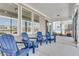 Enclosed patio with a set of blue chairs under a covered porch, perfect for outdoor relaxation at 302 Autumn Azalea Way, Summerville, SC 29486