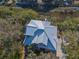 Aerial view of home with a metal roof surrounded by lush trees, waterways, and a driveway at 308 Jungle Rd, Edisto Beach, SC 29438