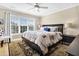 Cozy bedroom featuring a large window, ceiling fan, and black bedside table with lamp at 308 Jungle Rd, Edisto Beach, SC 29438