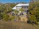 A back exterior view of a coastal home with multiple screened porches at 308 Jungle Rd, Edisto Beach, SC 29438