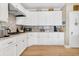 Well-lit kitchen featuring white cabinets, granite countertops, hardwood floors, and a stainless steel range hood at 308 Jungle Rd, Edisto Beach, SC 29438