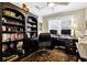 Home office with a large bookshelf, a desk with two computer monitors, and a patterned rug at 308 Jungle Rd, Edisto Beach, SC 29438