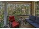 A cozy porch seating area with wicker furniture and forest views at 308 Jungle Rd, Edisto Beach, SC 29438
