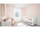 Charming Bedroom with a white crib, pink walls, and a cozy wicker chair at 317 Pine Crest View, Summerville, SC 29486