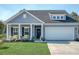 Beautiful blue home with a manicured lawn, welcoming front porch, and attached two car garage at 3278 Great Egret Dr, Johns Island, SC 29455
