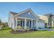 Charming home with a well-kept lawn, flowering shrubs, and an inviting front porch with yellow chairs at 3278 Great Egret Dr, Johns Island, SC 29455