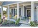 Inviting front porch with seating, decorative pillows, flowers, and tasteful decor that creates a welcoming ambiance at 3278 Great Egret Dr, Johns Island, SC 29455