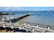 Scenic view of the waterfront with a long pier, bridge, and watercraft under a blue sky at 330 Concord St # 4C, Charleston, SC 29401
