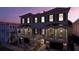 Charming townhomes with a lovely facade, green shutters, and cozy balconies over each garage at dusk at 4 Trapman St # A, Charleston, SC 29401
