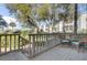 This outdoor deck has seating with a railing overlooking the surrounding trees and landscape at 409 Yacht Harbor Ct # 409, Isle of Palms, SC 29451