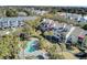 Aerial view of condos overlooking the pool, hot tub and sun lounging area surrounded by lush palm trees and green landscaping at 409 Yacht Harbor Ct # 409, Isle of Palms, SC 29451