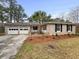 Charming brick home with a well-maintained lawn, mature trees and a two-car garage at 4341 Helene Dr, North Charleston, SC 29418
