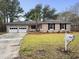 Charming brick home with a well-maintained lawn, mature trees and a two-car garage at 4341 Helene Dr, North Charleston, SC 29418
