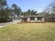 Charming brick home with a well-maintained lawn, mature trees and a two-car garage at 4341 Helene Dr, North Charleston, SC 29418