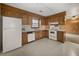 Open kitchen with wood cabinets, white appliances, and vinyl flooring at 4341 Helene Dr, North Charleston, SC 29418