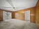 Large living room with wood paneled walls, sliding door access to the yard, and carpeted floors at 4341 Helene Dr, North Charleston, SC 29418