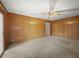 Spacious living room with wood paneled walls, a ceiling fan, carpeted flooring, and an open doorway at 4341 Helene Dr, North Charleston, SC 29418