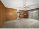 Open-concept living space featuring wood paneled walls, carpeted flooring, and seamless access to the kitchen at 4341 Helene Dr, North Charleston, SC 29418