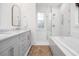 Bright bathroom featuring double vanity, large mirror, subway tile shower and a free standing tub at 493 Woodland Shores Rd, Charleston, SC 29412