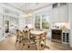 Bright dining room featuring modern light fixture, wine fridge and woven chairs with access to living room at 493 Woodland Shores Rd, Charleston, SC 29412