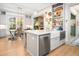 Kitchen featuring island with modern lighting, dishwasher, microwave, farmhouse sink, and view to dining room at 493 Woodland Shores Rd, Charleston, SC 29412