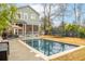 Inviting backyard pool area with lounge seating, screened porch, and a trampoline at 493 Woodland Shores Rd, Charleston, SC 29412