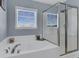 Bright bathroom featuring a glass enclosed shower, soaking tub and sunny window at 5073 Blair Rd, Summerville, SC 29483