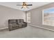 Bonus room featuring a large gray couch, two windows, and neutral walls at 5073 Blair Rd, Summerville, SC 29483